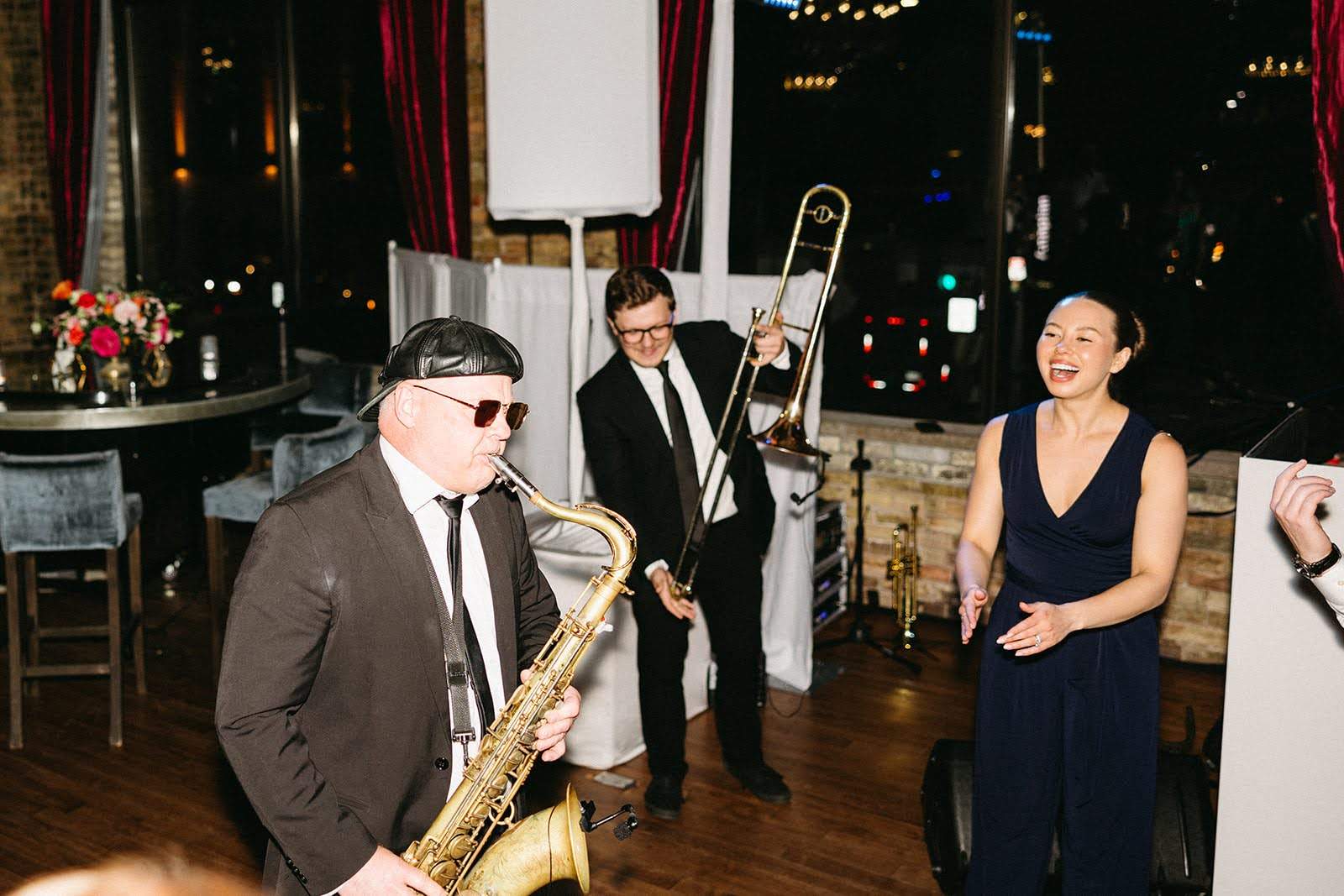 Man playing saxophone with two people watching